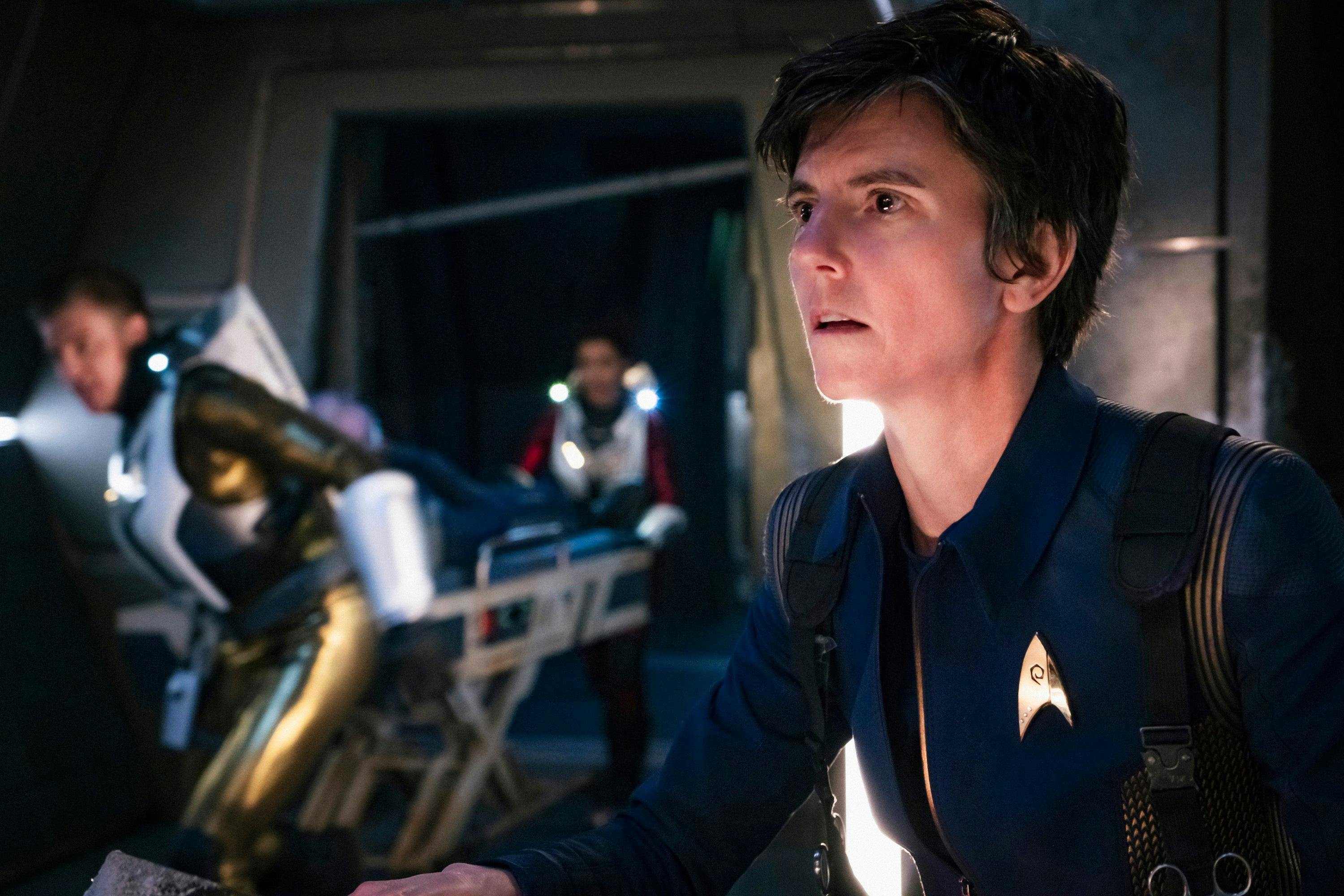 A close-up of Jett Reno at her station as Starfleet medics rush behind her in 'Brother'